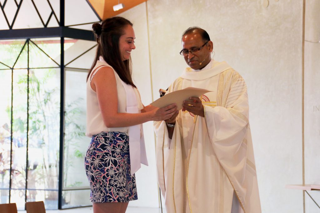 Eleisha Hathaway receiving her certificate from College Chaplain Fr Alfred Saminedi after being fully initiated in the Catholic Church Photo: Supplied 