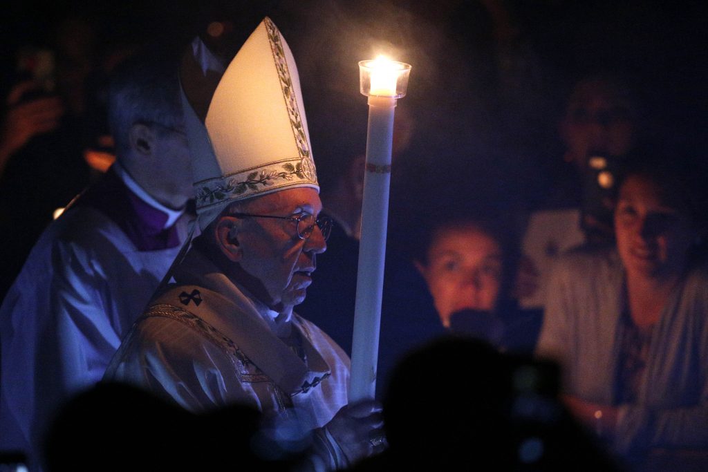 Pope Francis carries a candle as he arrives to celebrate the Easter Vigil in St Peter's Basilica at the Vatican on 15 April 15. Photo: Paul Haring/CNS