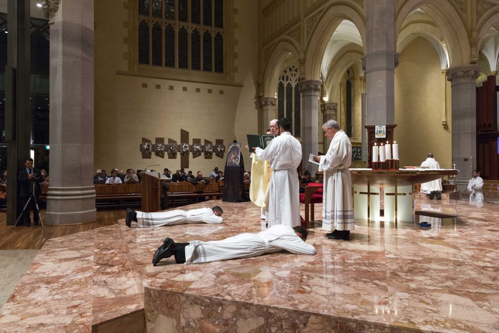 Max Kenneth Acosta Garcia and Patricio Carrera Morales lay prostrate on the ground during their Ordination to the Diaconate on Friday 31 March at St Mary’s Cathedral. Photo: Ron Tan