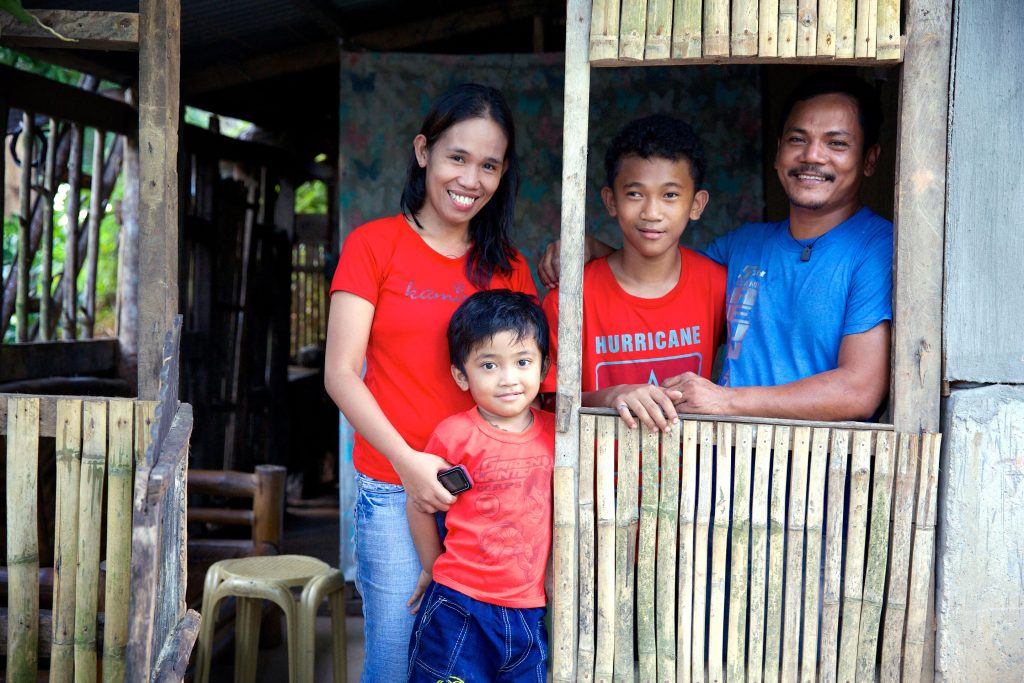 Aloma with her husband Ferdinand and their two sons Aloysius (12) and Andrei (5) in their home in Baranguy Pag-Asa. Photo: Richard Wainwright/Caritas Australia