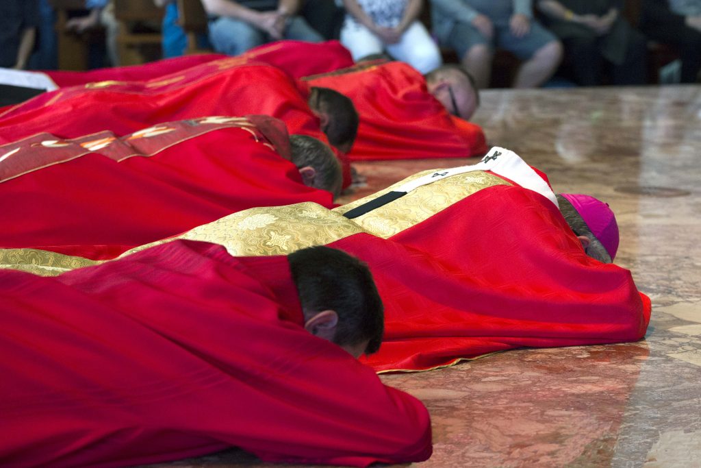 Archbishop Costelloe and concelebrants lie prostrate on the sanctuary on Good Friday, in an act of complete worship of the crucified Christ who gave his life for our salvation. Photo: Ron Tan