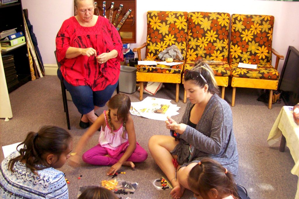 Making rosary beads with the colours of the Aboriginal flag (red, black and yellow) was one of the activities enjoyed during the Children’s Community Day at the Aboriginal Catholic Ministry last month. Photo: Supplied