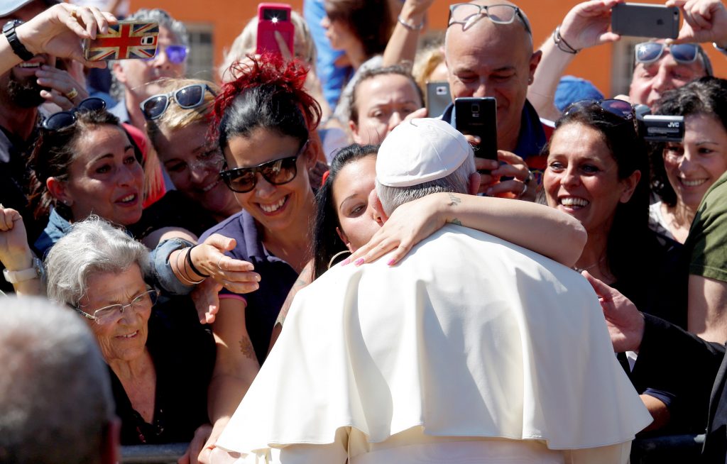 A woman kisses Pope Francis as he arrives for a visit at the parish of San Pier Damiani on 21 May at Casal Bernocchi on the outskirts of Rome. Photo: CNS/Remo Casilli, Reuters.