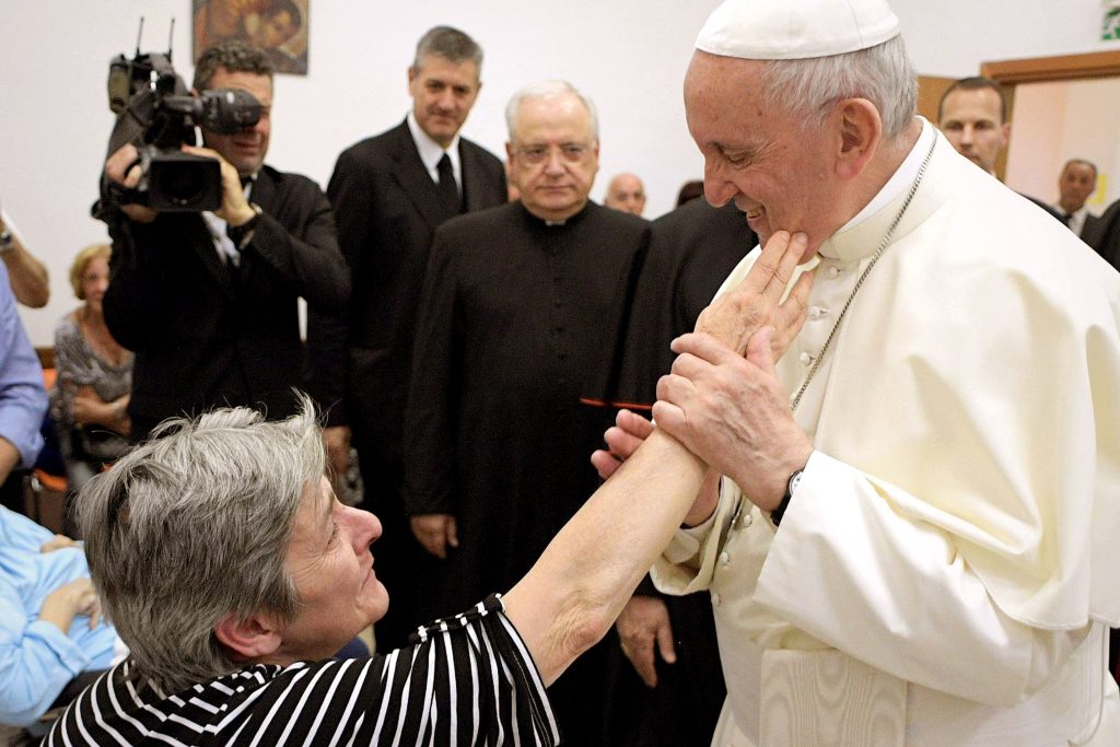 A woman touches Pope Francis' cheek during a visit to the parish of San Pier Damiani on 21 May at Casal Bernocchi on the outskirts of Rome. Photo: CNS/Remo Casilli, Reuters. 