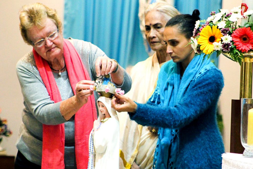 Maida Vale parishioners Betty Flynn, Luciana Sasidhran & Amber David place a crown on the top of a statue of Our Lady of Fatima during the annual Flores de May celebrations to commemorate the feast of Our Lady of Fatima. Photo: Supplied.