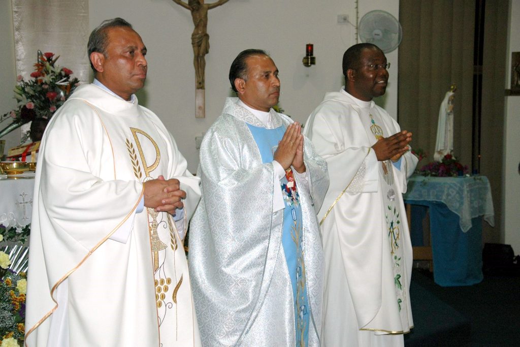 Girrawheen Parish Priest Father Albert Saminedi (centre) celebrating Mass with Fr Bonaventure Echeta (right) and his brother, Rev Dr Julian Saminedi (left) who came from Germany for the occasion. Photo: Supplied. 