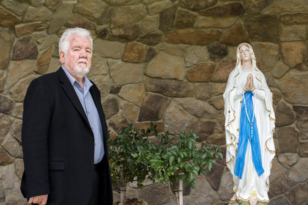 Ocean Reef Parish Council Chair John Hollywood has a special connection to the Our Lady of Lourdes statue which adorns the parish grotto, built last year. Photo: Caroline Smith.