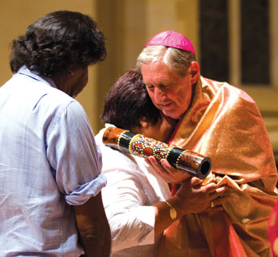 Archbishop Barry Hickey smiles as he receives a parting gift from two Aboriginal members of the congregation in St Mary’s Cathedral last Tuesday night 6 March.