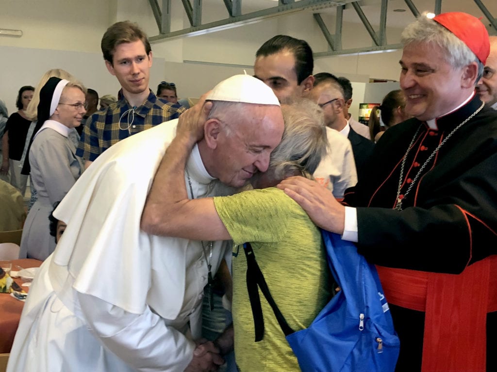 Pope Francis greets a man during a dinner for the poor hosted by new Cardinal Konrad Krajewski, the papal almoner, right, in the dining hall at the Vatican on 29 June 29. Photo: CNS/Gianna Lasilli.