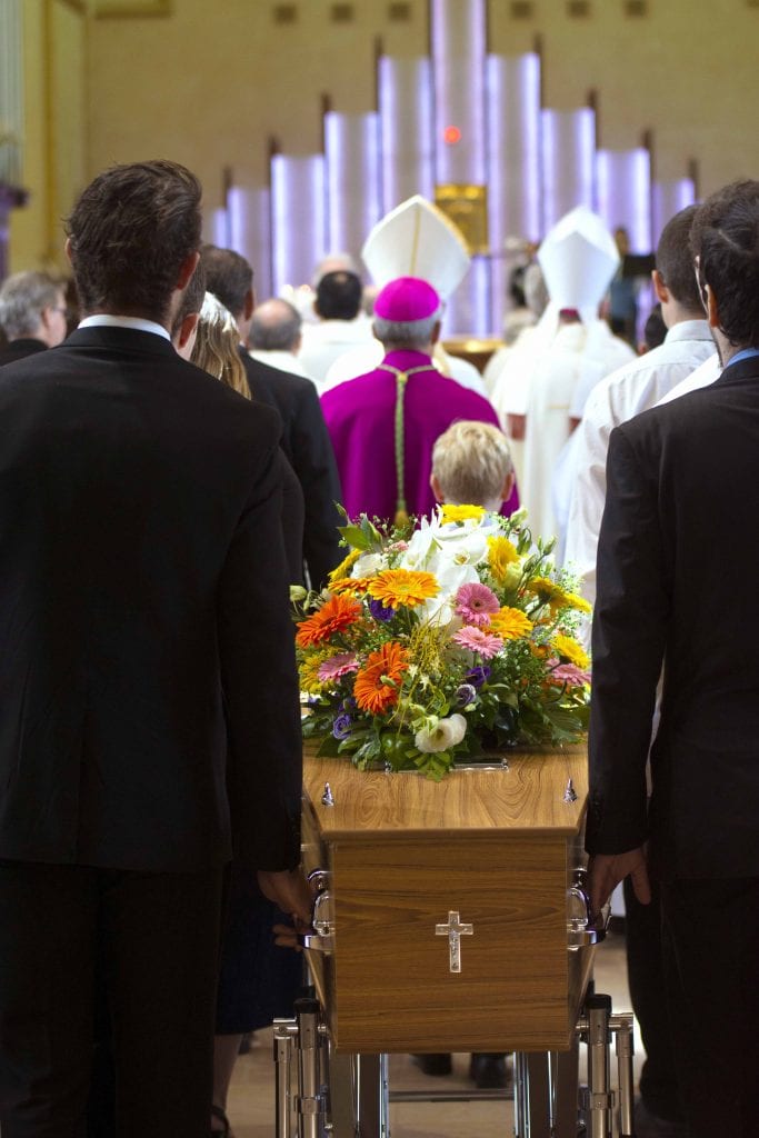 Fr Pitzen’s casket is ushered into the St Mary’s Cathedral by his loved ones. Photo: Josh Low.