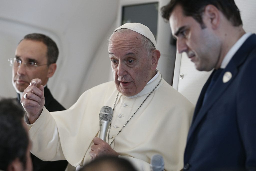 Pope Francis answers questions from journalists aboard his flight from Abu Dhabi, United Arab Emirates, to Rome on 5 February 2019. Also pictured are Msgr Mauricio Rueda, papal trip planner, and Alessandro Gisotti, interim Vatican spokesman. Photo: CNS/Paul Haring.