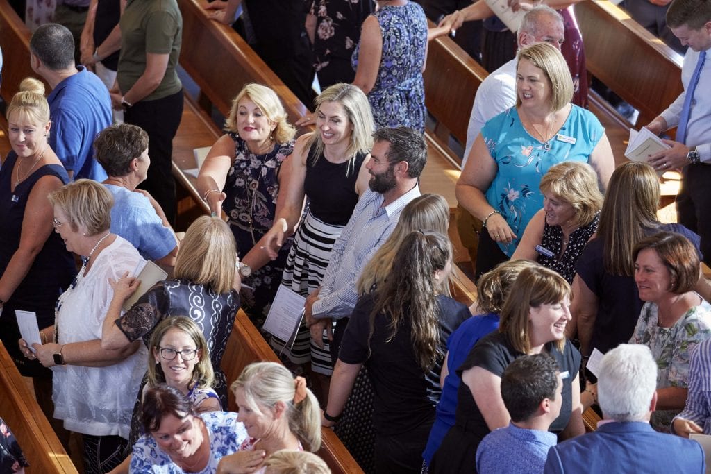 CEWA staff greet one another with “the sign of peace” at St Mary’s Cathedral on Friday 1 February. Photo: Ron Tan.