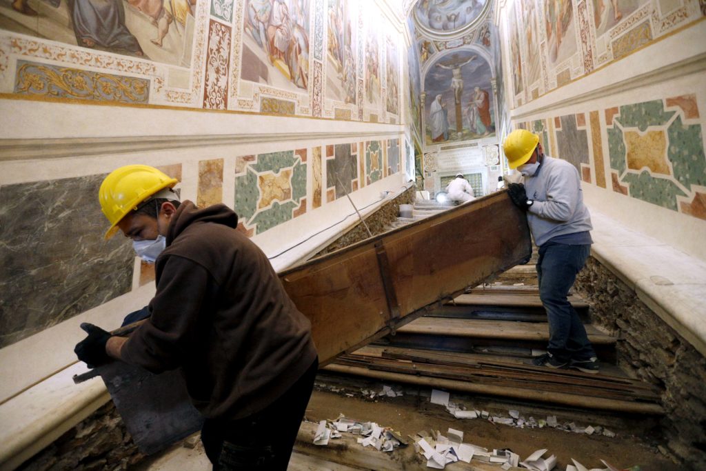 Notes from pilgrims are seen as workers remove a wooden covering over the Holy Stairs at the Pontifical Sanctuary of the Holy Stairs in Rome March 15, 2019. Pilgrims will have the opportunity to climb the bare marble stairs for at least a month after an April 11 unveiling of the renovated sanctuary. Photo: CNS/Paul Haring. 