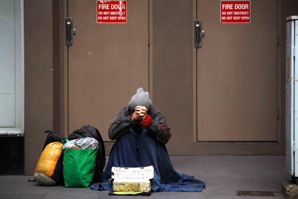 A homeless man begs for money on a street in Sydney in 2014. While Australia has one of the world's highest levels of average net wealth per person, nearly three million Australians, including more than 730,000 children, live in poverty. Photo: CNS/David Gray, Reuters.