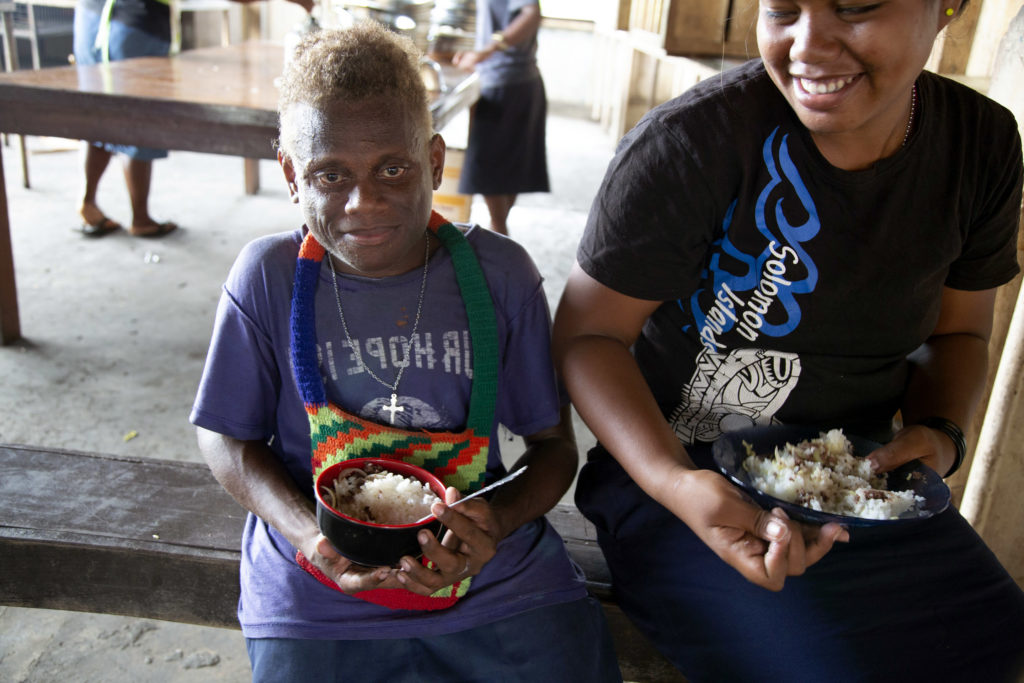Peter and his friend eat lunch at the Aligegeo Secondary School. Photo: Cassandra Hill/ Caritas Australia.