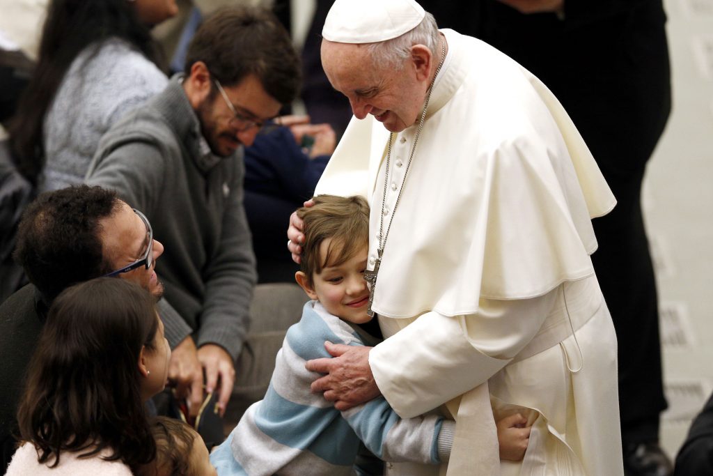 A boy embraces Pope Francis during his general audience in Paul VI hall at the Vatican ON 9 January 2019. Photo: CNS/Paul Haring.