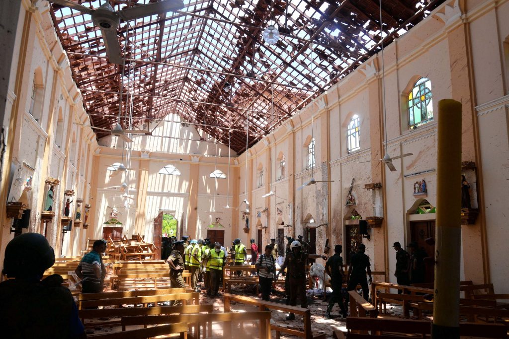 Nuns, clergymen and police officials look over the scene after a bombing where at least 350 people have been killed on Easter Sunday in Sri Lanka. Photo: Reuters/CNS.