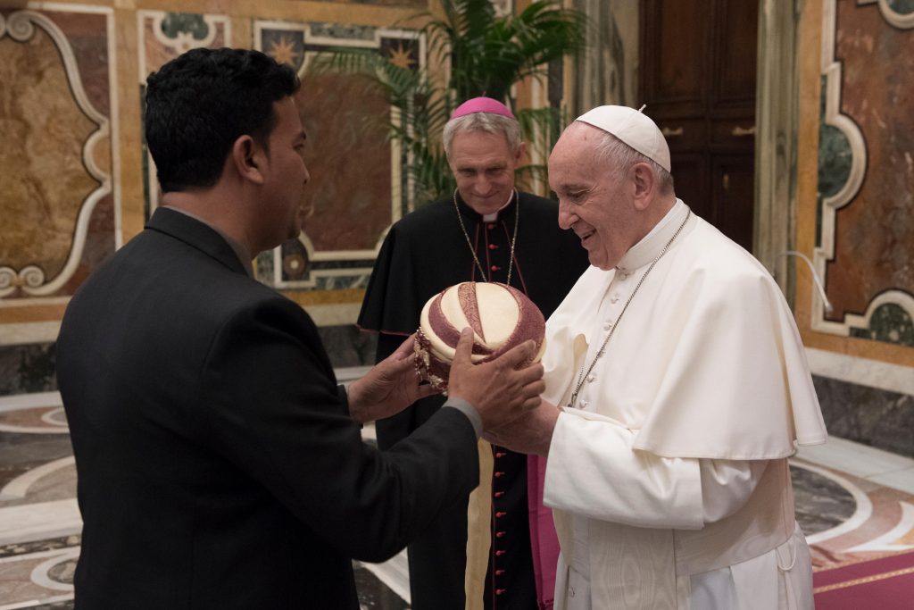 Pope Francis is presented with a turban during a meeting on 26 April at the Vatican with members of the Catholic Biblical Federation. At centre is Archbishop Georg Ganswein, prefect of the papal household. Photo: Vatican Media/CNS.