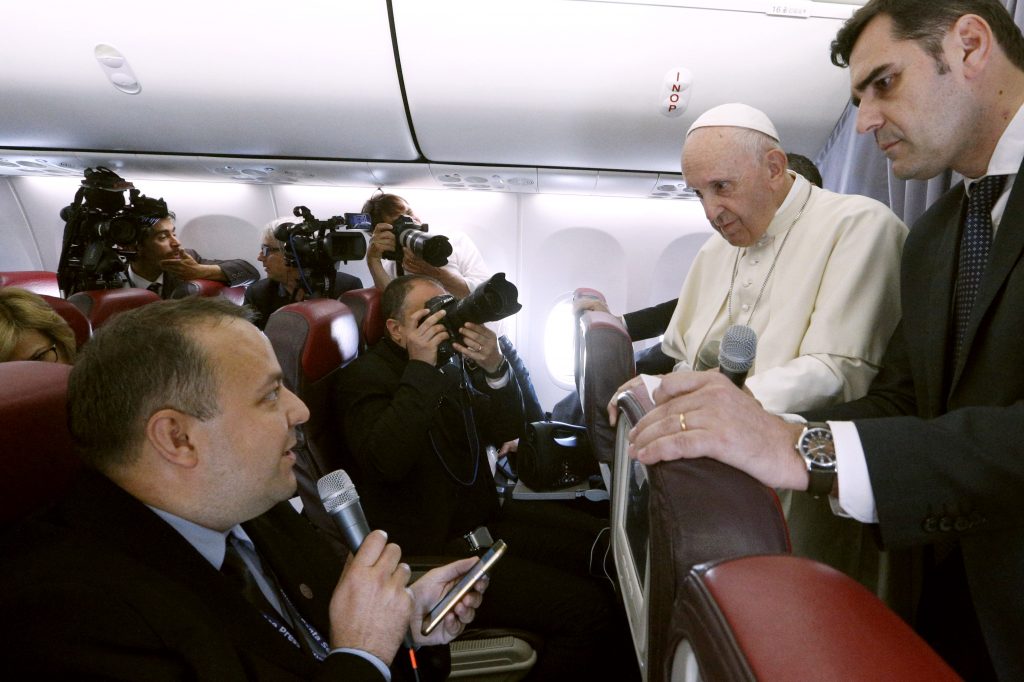 Pope Francis listens to a question from Romanian journalist Cristian Micaci aboard his flight from Sibiu, Romania, to Rome on 2 June. Photo: Paul Haring/CNS.