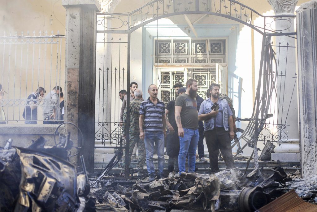 People gather at the site of a car bomb blast outside the Syriac Orthodox Church of the Blessed Virgin Mary in Qamishli, Syria on 11 July 2019. Photo: Rodi Said/Reuters.