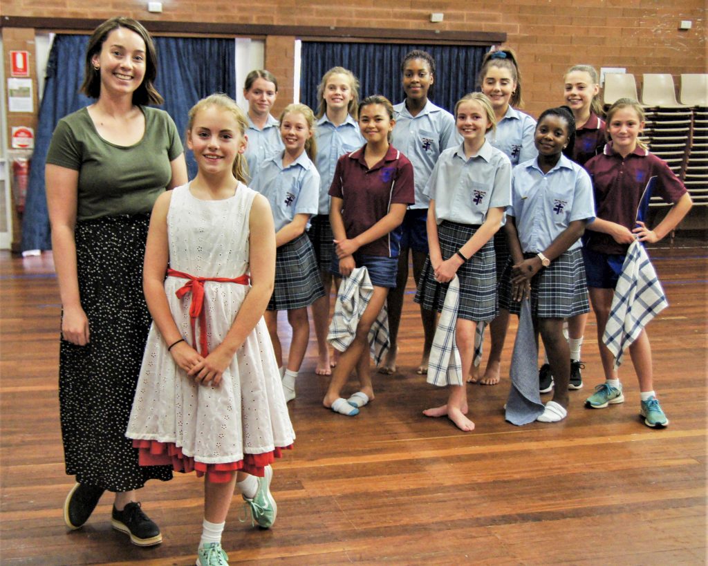 Dance and drama teacher Teegan Dean with Lillian O'Donnell, who played Annie, along with other JPC students. Photo: Supplied.