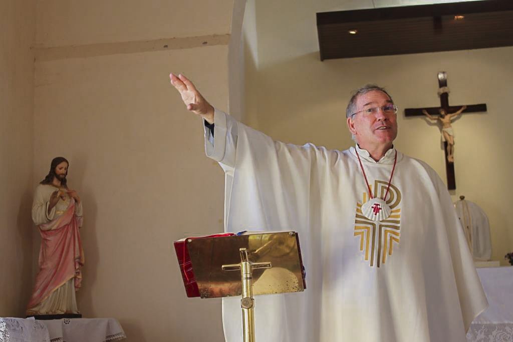 Fr Robert Cross, Director of Heritage for the Diocese of Geraldton, wearing the clamshell traditionally associated with pilgrims on a Camino, as he explains the significance of certain aspects of the architectural design of Monsignor Hawes. Photo: Supplied.