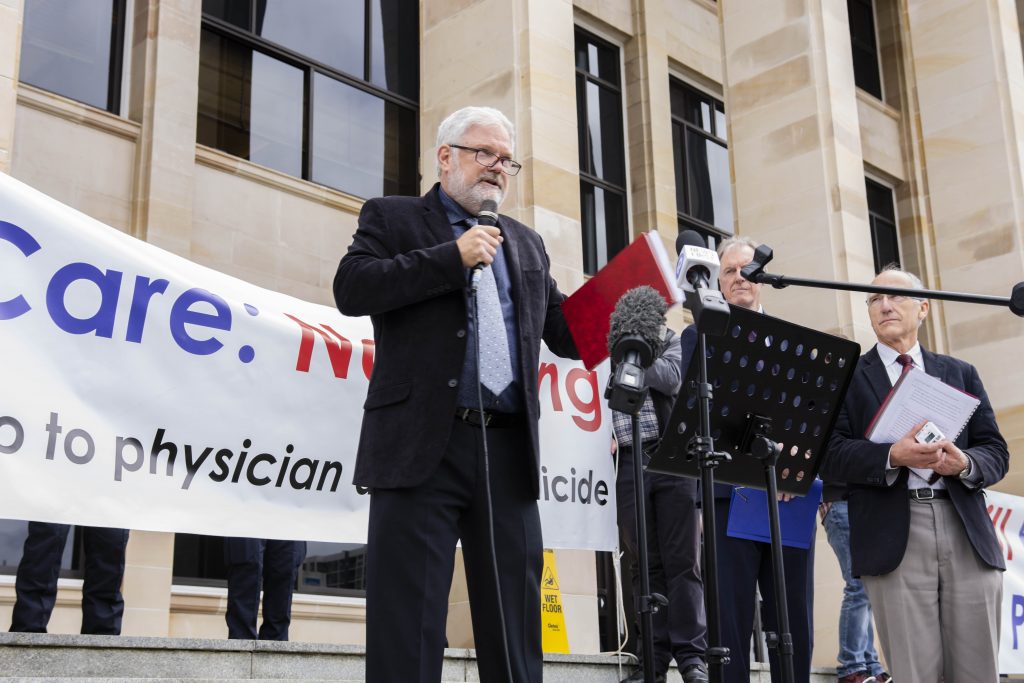 Fatal Flaws filmmaker Kevin Dunn delivers a dynamic presentation to the CARE: Not Kill rally. Photo: Eric Martin.
