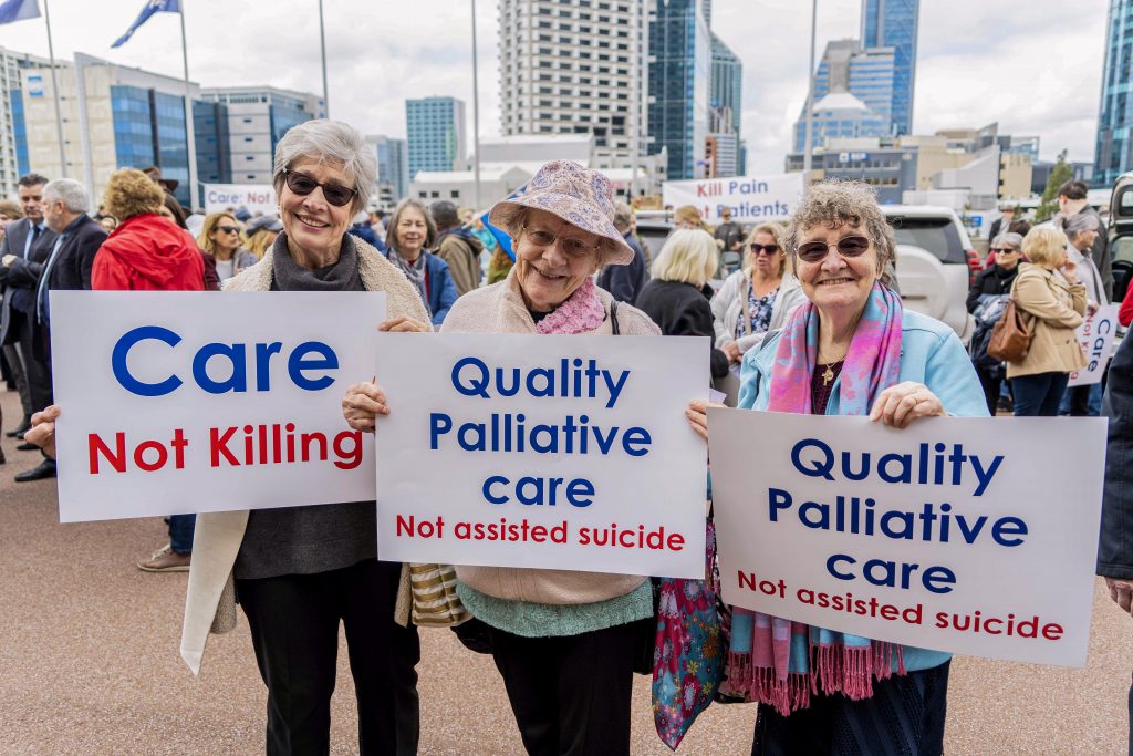 Peaceful protestors hold placards showing their support for palliative care as the preferred treatment option for the elderly. Photo: Josh Low.