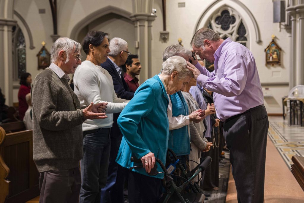 Parishioners of St Joseph’s Subiaco gather to have Alan lay hands on them in prayer for healing. Photo: Eric Martin.